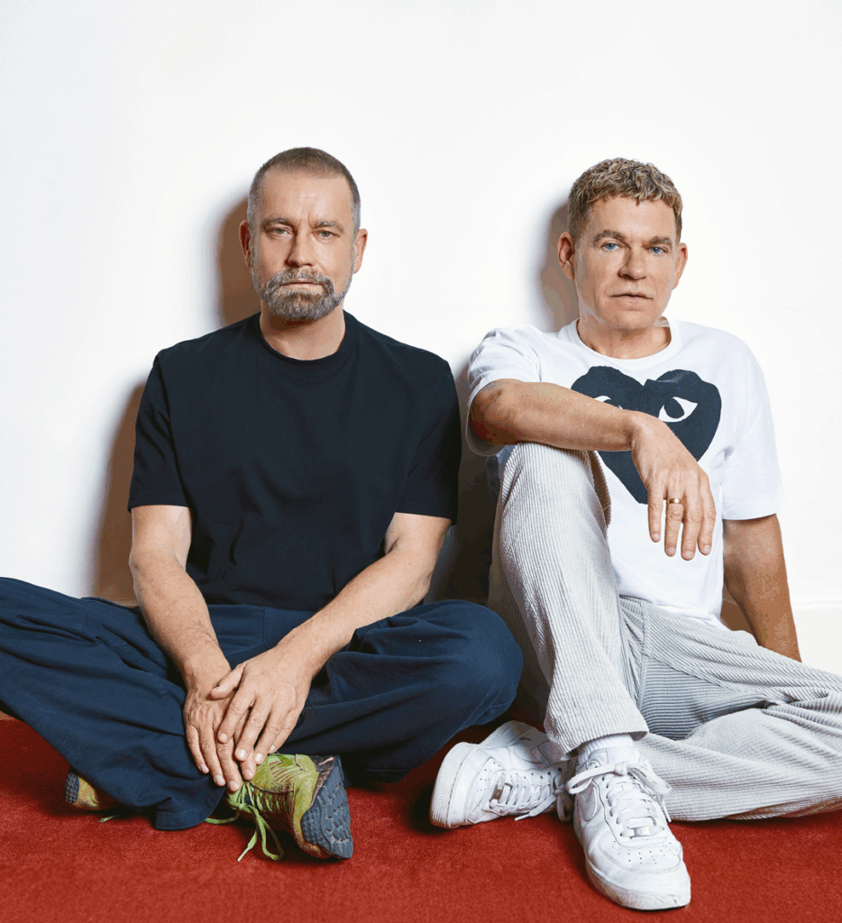 Ulf und Peter sitzen entspannt auf dem Fußboden und schauen nach vorn